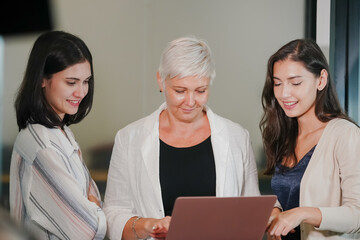 Happy smiling business women working together online on a laptop in office