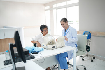 Obraz premium Female doctor doctor measuring senior female's blood pressure at medical clinic.
