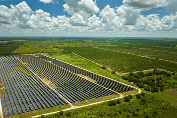 Aerial view of sustainable electrical power plant between agricultural farmlands with photovoltaic panels for producing clean electric energy. Concept of renewable electricity with zero emission - obrazy, fototapety, plakaty