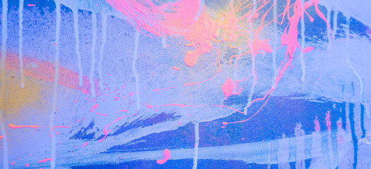Messy paint strokes and smudges on an old painted wall background. Abstract wall surface with part of graffiti. Colorful drips, flows, streaks of paint and paint sprays
