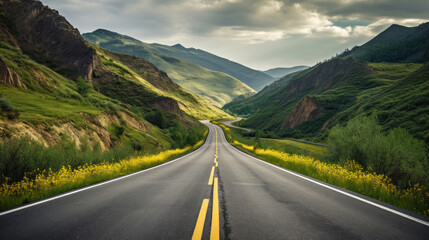 A Black Asphalt Road Leading Into The Mountains During Summer