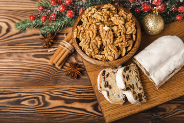 Christmas stollen on a texture table. Traditional German Christmas dessert cut into pieces. Cake with nuts, cinnamon, raisins, dried fruits and marzipan. baking for christmas. Place for text. 