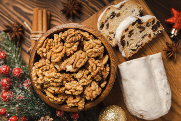 Christmas stollen on a texture table. Traditional German Christmas dessert cut into pieces. Cake with nuts, cinnamon, raisins, dried fruits and marzipan. baking for christmas. Place for text. 