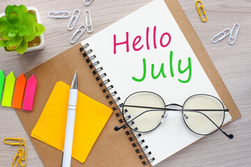 hello july on notepad on wooden background - obrazy, fototapety, plakaty