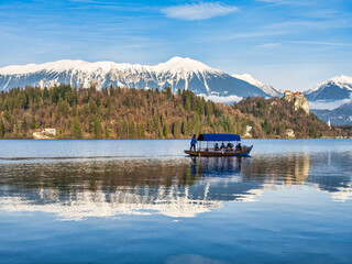 Rowing boat in lake Bled, snow peak mountains and the castle in the background, Slovenia