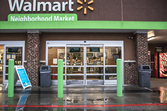 Walmart neighborhood grocery store in the rain entrance and covid-19 sign