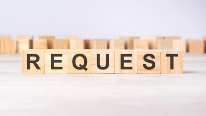 text REQUEST on wooden cubes on bright grey background. square wood blocks. top view, flat