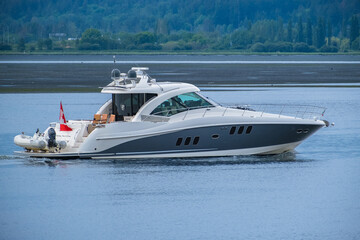 Luxury motor yacht in navigation. White and blue luxury yacht in motion. Modern powerboat speeding...