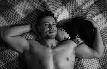 Handsome man lying with baby. Happy father with child on a bed.
