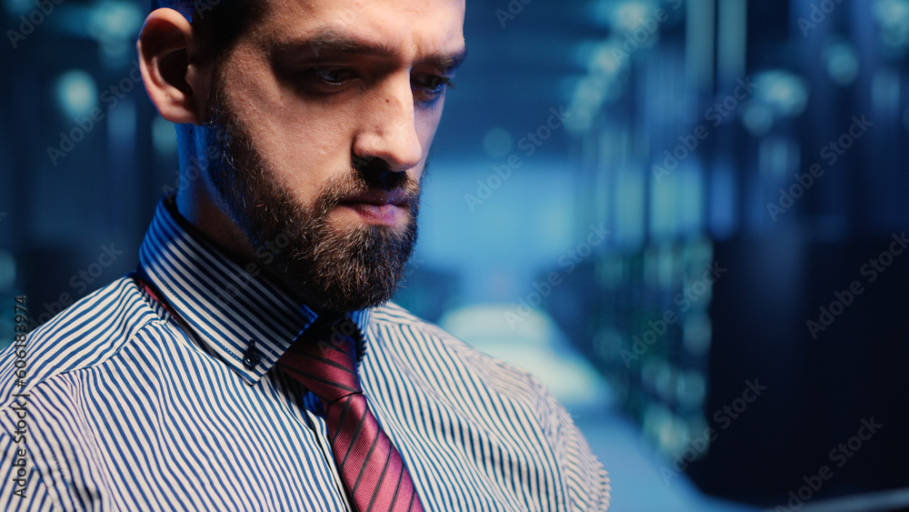 Poster system administrator standing in modern data center, checking supercomputer networking service on ta