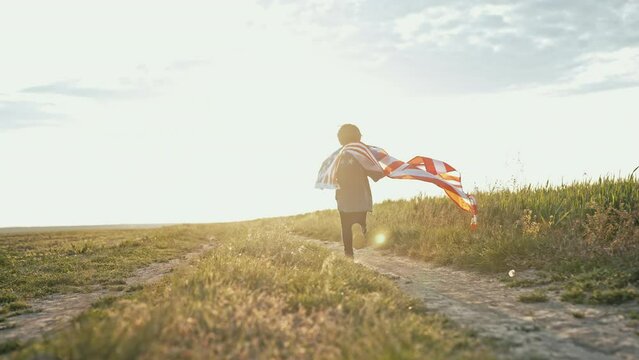 Cute little boy - American patriot kid running with national flag on open area countryside road.USA, 4th of July - Independence day, celebration. US banner, memorial Veterans, election, America, labor