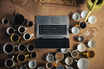 Recycling, deadline, awake concept. Laptop, many cups of coffee. View from above.