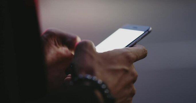 Typing, closeup and male hand using smartphone at night or on city street or search for ride and sending message for communication on mobile. Writing, sms and texting on social network or emailing