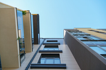 Modern multi-storey house in a new residential complex against the blue sky. The concept of mortgage housing lending and a happy family life. Beautiful multicolored house in the city