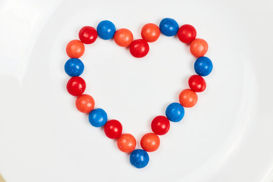 Skittles heart with blue and red and orange on white background asset