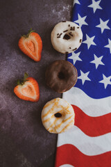 Donuts. Top view. Colorful donuts with icing. On the black background . Colorful glazed doughnuts with sprinkles. Independence Day 4th of July