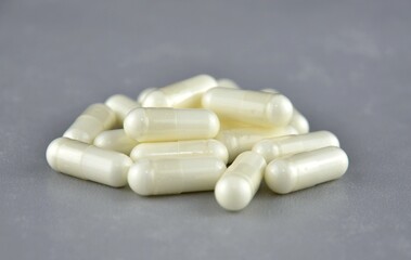 Fototapeta na wymiar Light yellow vitamin C capsules (pills) on a gray background