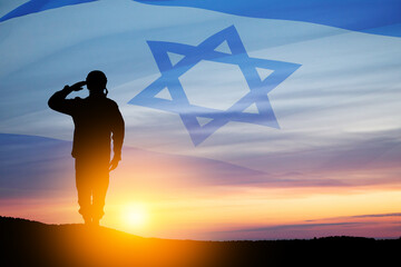 Silhouette of soldier saluting against the sunrise in the desert and Israel flag. Concept - armed forces of Israel.