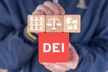 Man holding colorful blocks with abbreviation: DEI. Concept of DEI Diversity Equality Inclusion...