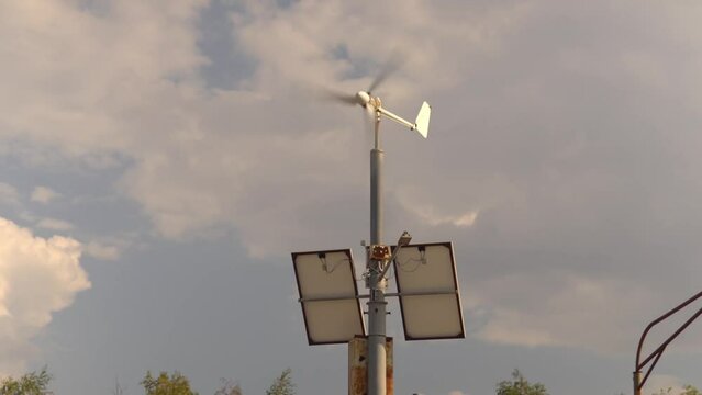 solar panels and a wind turbine installed on a pol