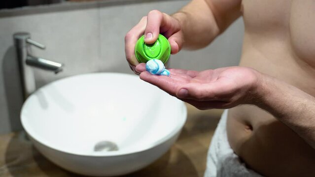 Man Applying Shave Foam On Arm While Standind Near Mirror In Bathroom, Close Up
