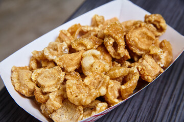 Pork Rinds chicharrones white tray red stripes slate gray textured blurred background food