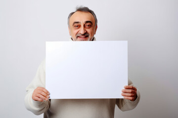 Portrait of an elderly man holding a white sheet of paper.