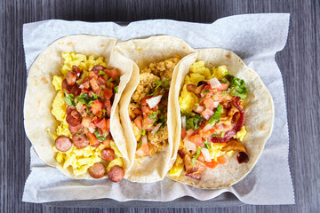 3 flour tortilla Mexican breakfast tacos sausage chorizo bacon with toppings background asset
