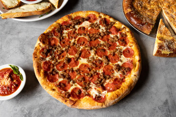 pizza with pepperoni and sausage on a table, top view, space for text