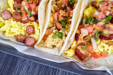 3 breakfast tacos Mexican Hispanic with egg toppings cilantro, onion, and tomato