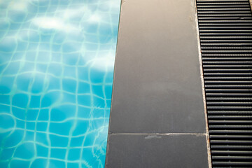 Black gutter is installed beside swimming pool, drainage system, overflow gutter, private pool,...