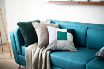 blue couch with pillows and blankets on top of it in the corner
