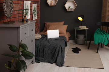 Stylish teenager's room with laptop, bed and chest of drawers