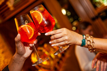 couple cheering Apperol spritz drink close up
