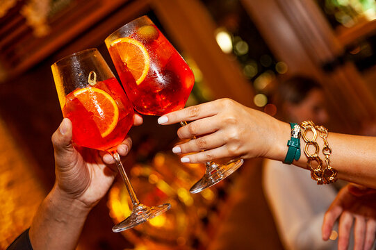 couple cheering Apperol spritz drink close up