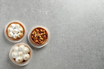 Fototapeta na wymiar Different tartlets on light grey table, flat lay with space for text. Tasty dessert