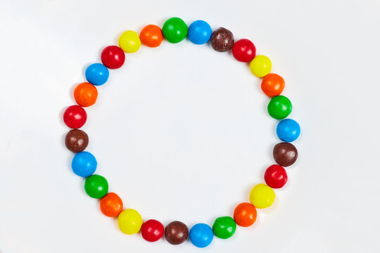 Circle of skittles candy on white background asset
