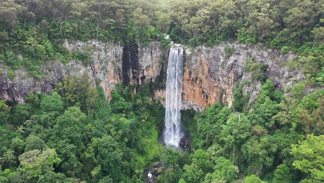 Aerial view with a rotation across Purling Brook falls at full flow. Gold Coast hinterland
