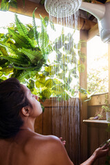 Blissful Moments: Woman Testing the Water Temperature in Relaxing Outdoor Glamping Shower