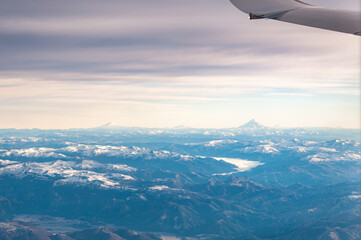 View of the snow covered Andes Mountains through the window of an airplane at sunrise