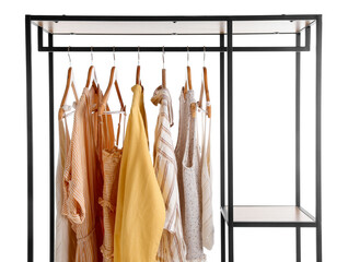 Shelving unit with summer clothes on white background