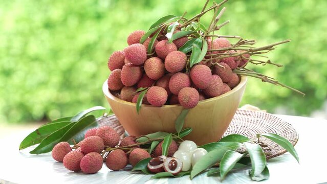 Lychee Fruite in wooden basket, Lychee fruit under sunlight on blurred nature background.
