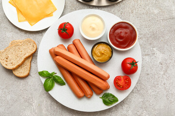 Board of tasty sausages with basil and cheese on grey background