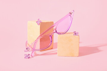 Podiums with stylish sunglasses on pink background