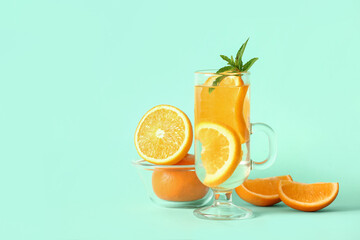 Glass of infused water with orange slices on blue background