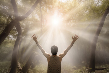 Fototapeta na wymiar a man standing in the middle of the forest with arms outstretched in the bright morning sunray