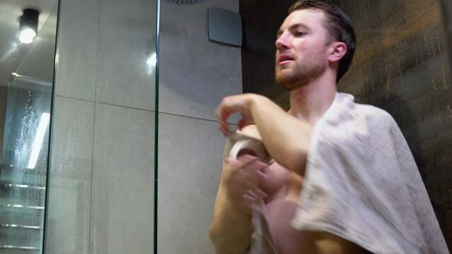 A man is wiped with a towel after a shower in luxury hotel bathroom
