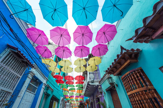 Cartagena, Bolivar, Colombia. March 15, 2023: Getsemani neighborhood Calle de la Magdalena decorated with colorful umbrellas and drawings.