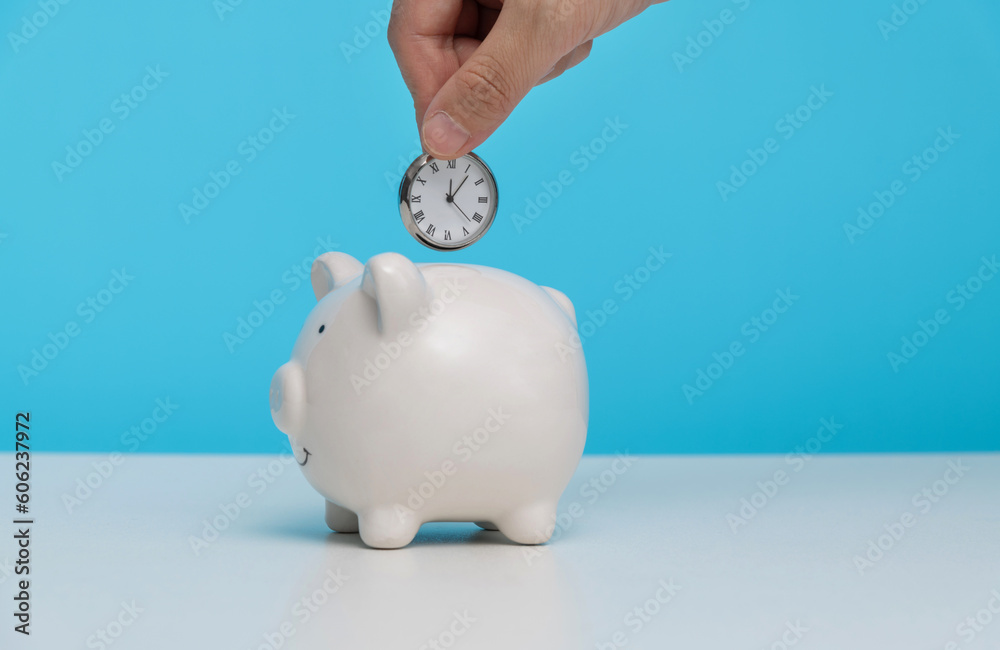 Wall mural hand putting clock into piggy bank