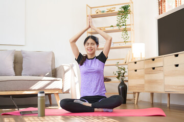 Fototapeta na wymiar Sporty woman meditating to practice yoga exercise while raise hands to doing yoga with namaste pose